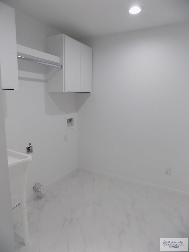 laundry area with hookup for a washing machine and cabinets