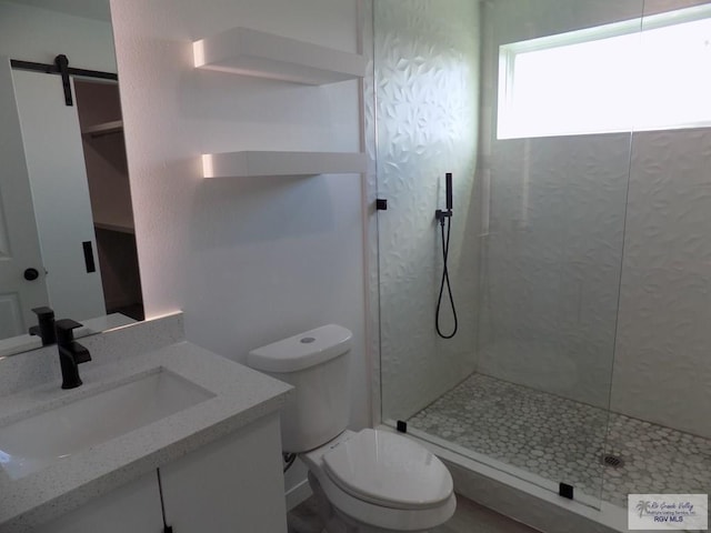 bathroom with vanity, toilet, and a tile shower