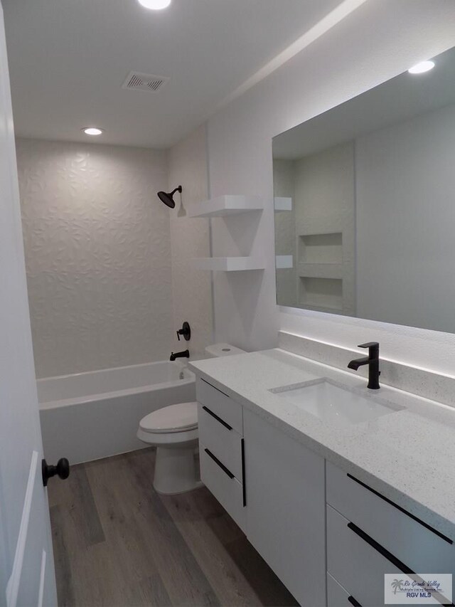 full bathroom with bathtub / shower combination, vanity, hardwood / wood-style flooring, and toilet