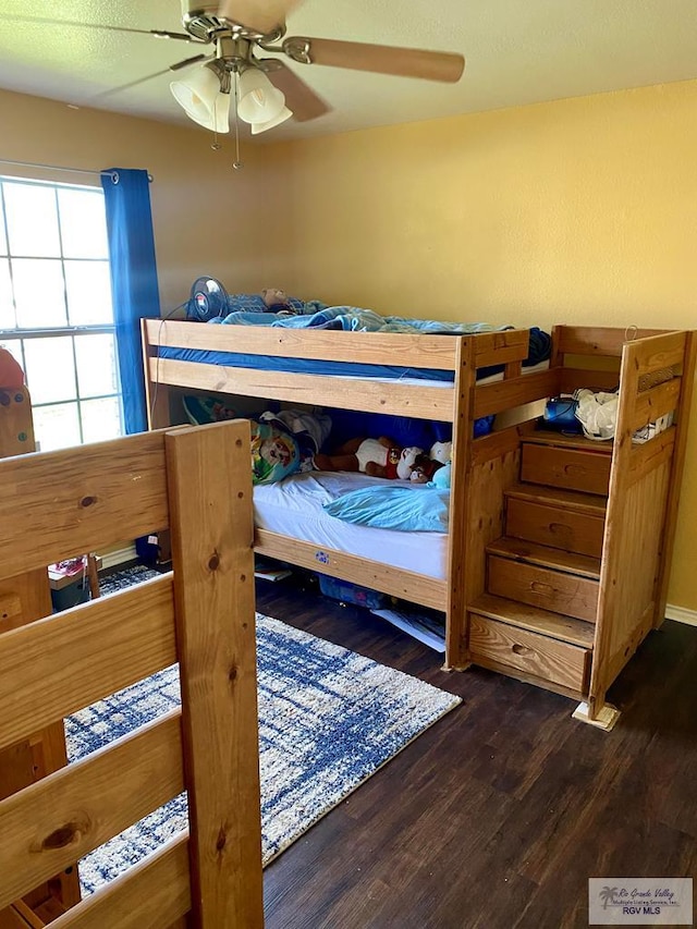 bedroom with dark hardwood / wood-style floors and ceiling fan