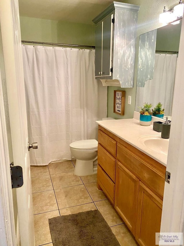 bathroom featuring vanity, toilet, and tile patterned floors