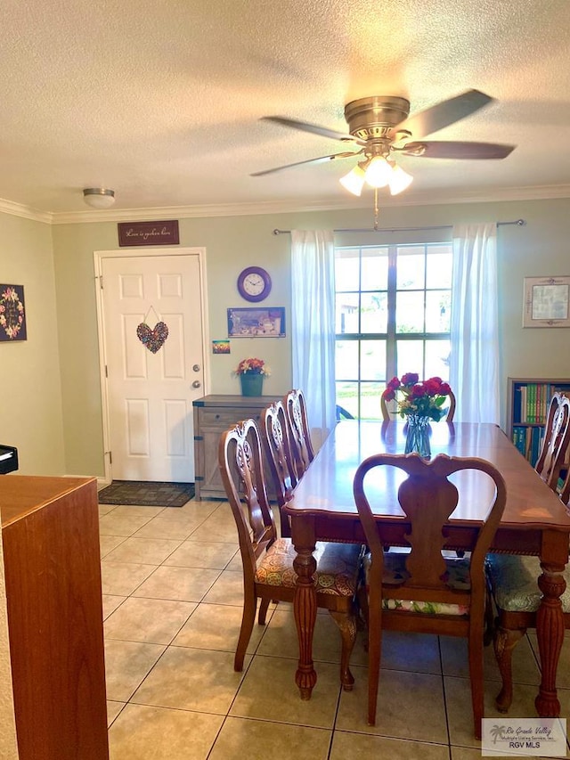 tiled dining room featuring ceiling fan, crown molding, and a textured ceiling