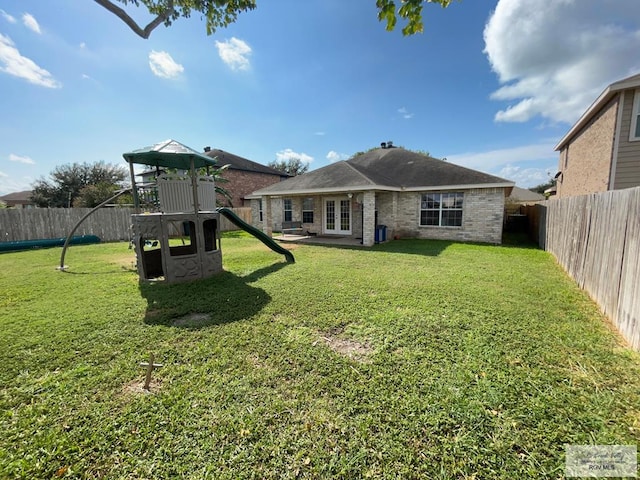 back of house featuring a lawn, cooling unit, and a playground