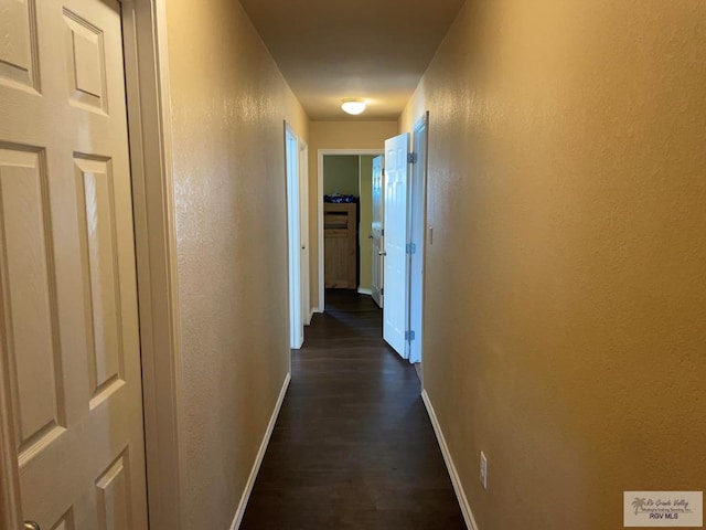 corridor with dark hardwood / wood-style flooring