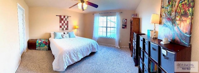 carpeted bedroom with ceiling fan and vaulted ceiling