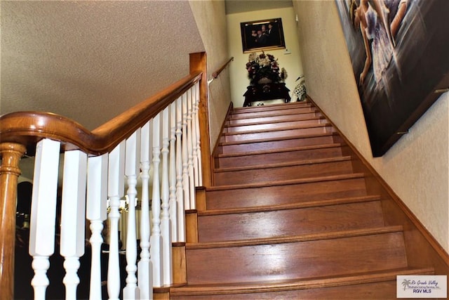 stairs featuring a textured ceiling