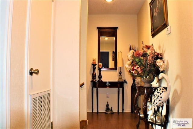 hallway featuring dark hardwood / wood-style floors and a textured ceiling