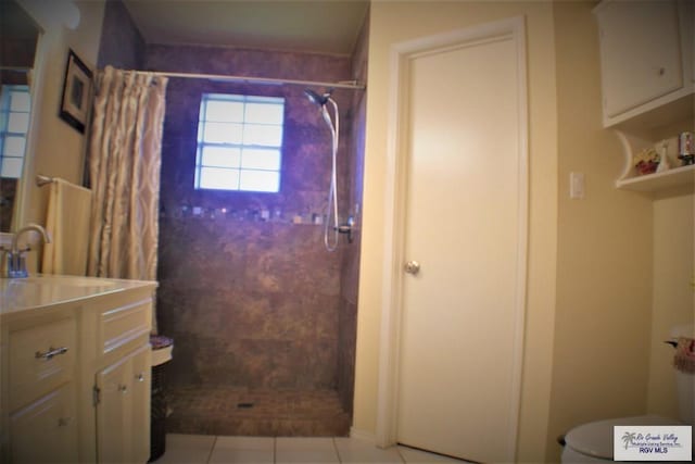 bathroom featuring tile patterned flooring, vanity, toilet, and walk in shower