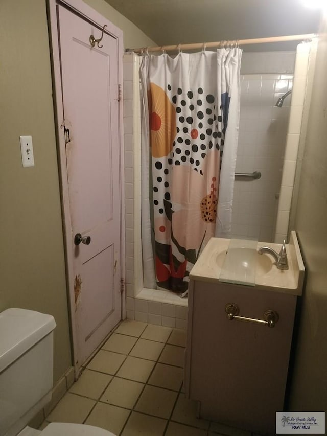 bathroom with tile patterned flooring, a shower with curtain, vanity, and toilet