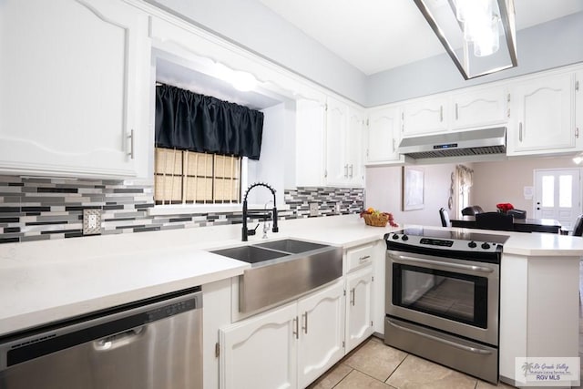 kitchen with kitchen peninsula, sink, white cabinets, and stainless steel appliances