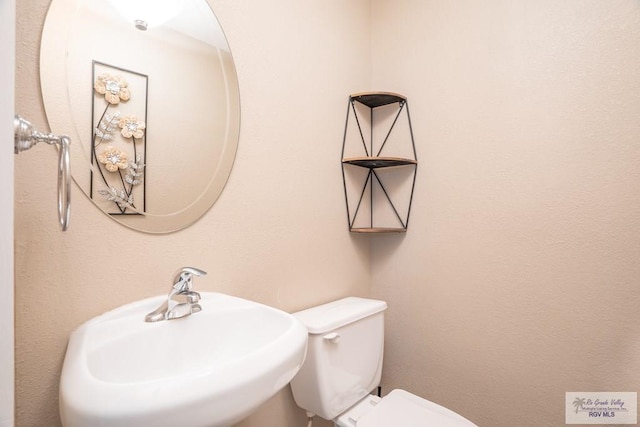 bathroom featuring toilet and sink