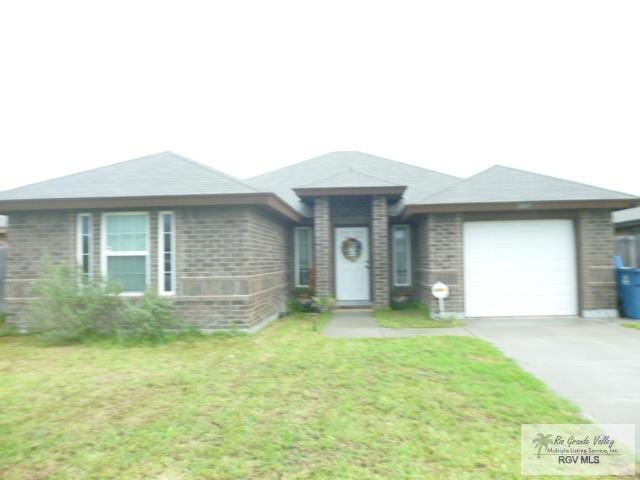 3937 Oak Valley Dr, Brownsville, TX 78520 - ranch-style home with an attached garage, concrete driveway, brick siding, and a front yard