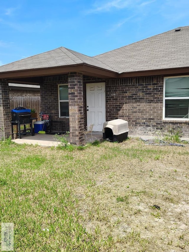 3937 Oak Valley Dr, Brownsville, TX 78520 - back of house with a patio area, brick siding, roof with shingles, and an attached carport