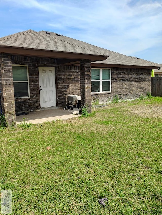 3937 Oak Valley Dr, Brownsville, TX 78520 - rear view of house featuring a patio area, brick siding, and a lawn