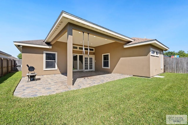 back of property with french doors, a patio, and a lawn