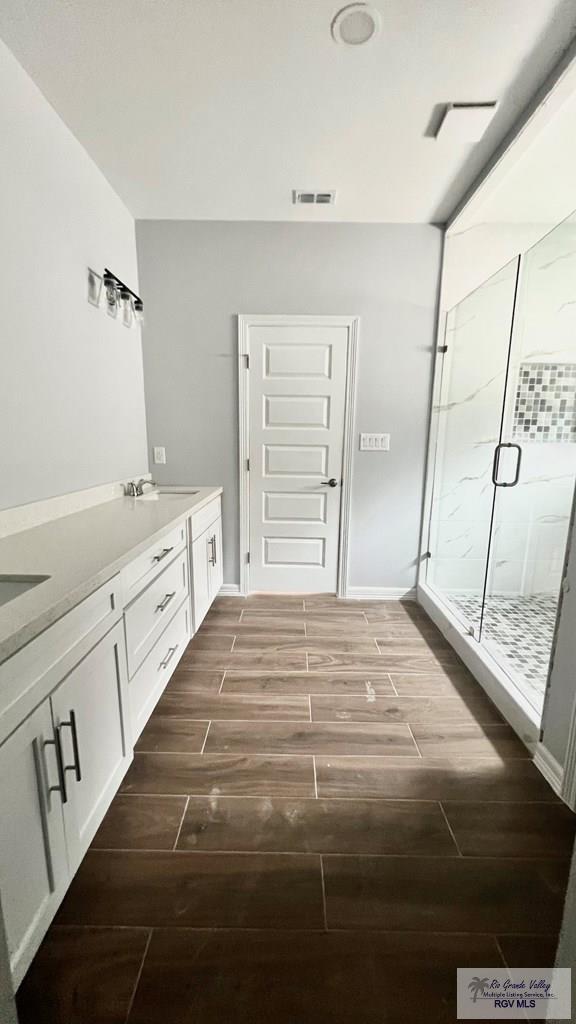 2517 S Christian Cir, Harlingen, TX 78550 - full bath with wood finish floors, a stall shower, and double vanity