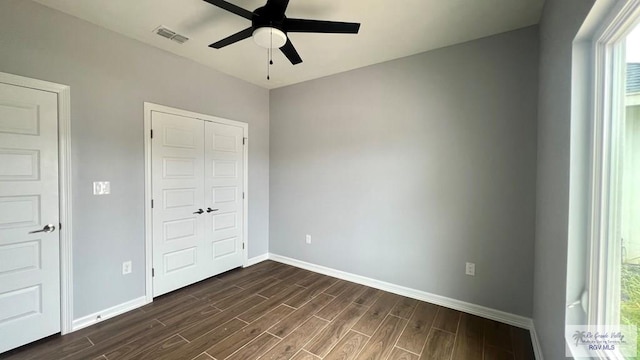 2517 S Christian Cir, Harlingen, TX 78550 - unfurnished bedroom featuring dark wood-style floors, multiple windows, a closet, and ceiling fan
