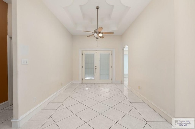 tiled spare room featuring ceiling fan and french doors