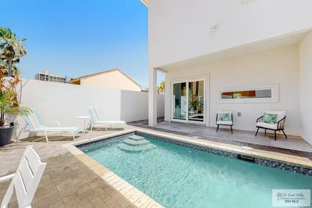 view of swimming pool featuring a fenced in pool, a fenced backyard, and a patio
