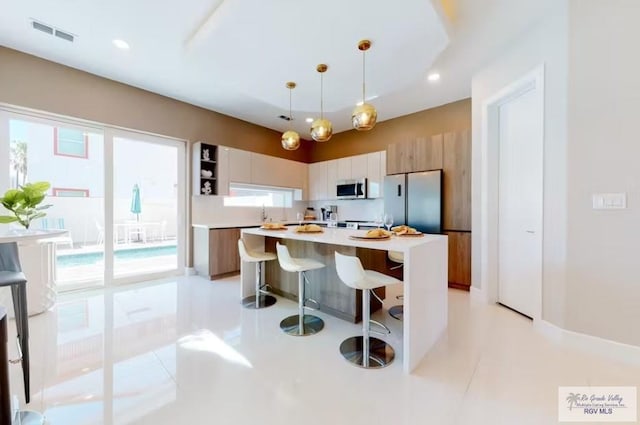 kitchen with visible vents, appliances with stainless steel finishes, modern cabinets, open shelves, and a center island