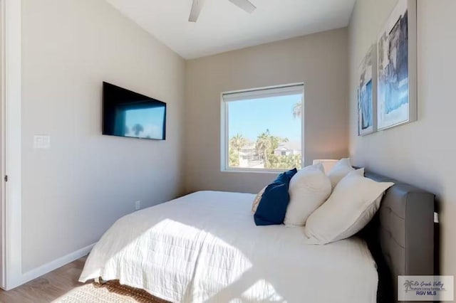 bedroom featuring baseboards, a ceiling fan, and wood finished floors