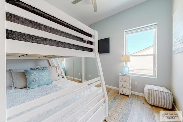 bedroom featuring baseboards, ceiling fan, and wood finished floors