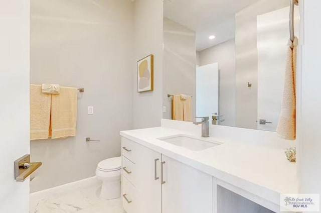 bathroom featuring vanity, marble finish floor, toilet, baseboards, and recessed lighting