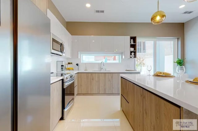 kitchen with visible vents, a sink, modern cabinets, and stainless steel appliances