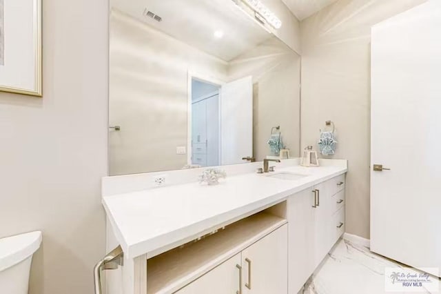 bathroom with vanity, visible vents, toilet, and marble finish floor