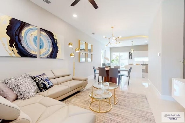 tiled living area with recessed lighting and ceiling fan with notable chandelier