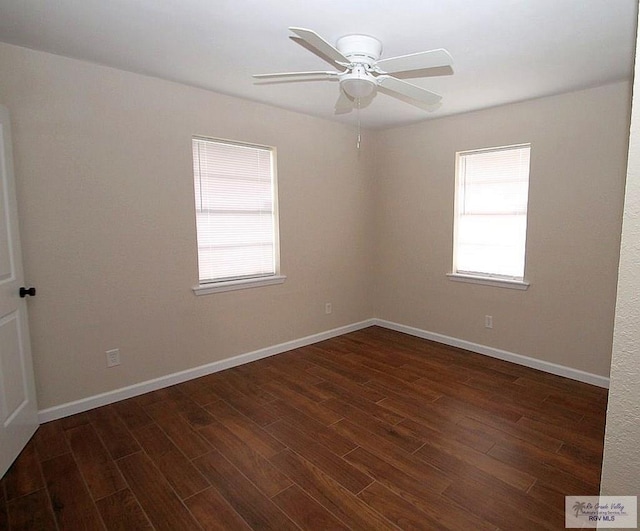 empty room featuring dark hardwood / wood-style flooring, a wealth of natural light, and ceiling fan