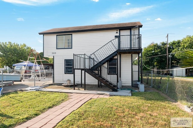 rear view of property featuring a lawn