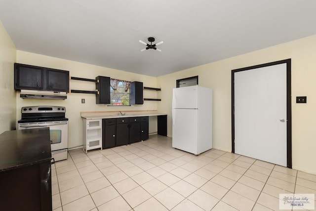 kitchen featuring electric range, sink, white fridge, and light tile patterned floors