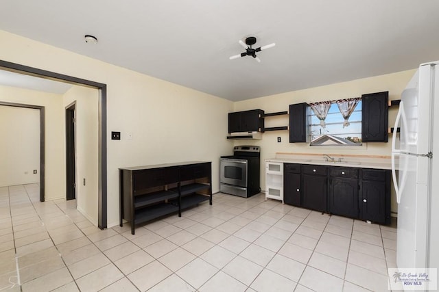 kitchen featuring light tile patterned floors, electric range, white fridge, and sink