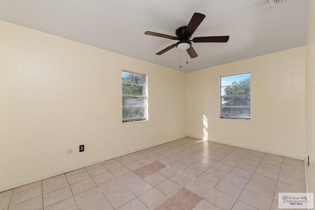 tiled empty room featuring ceiling fan