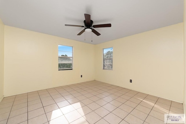 tiled spare room with ceiling fan