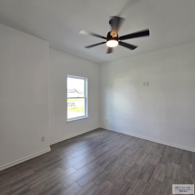 empty room with dark hardwood / wood-style flooring and ceiling fan