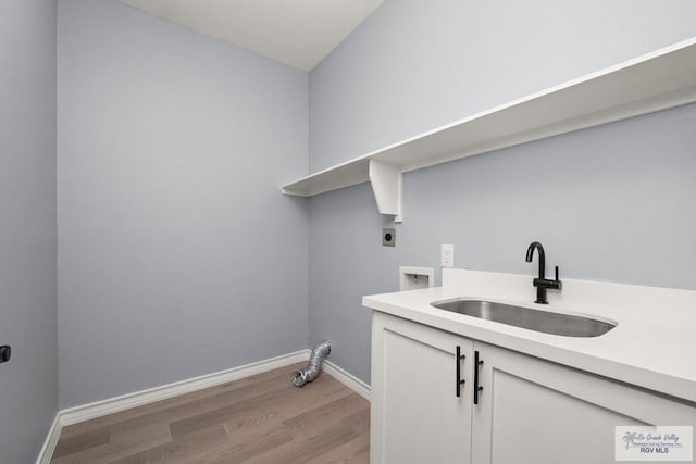 washroom with cabinets, sink, light hardwood / wood-style flooring, and electric dryer hookup