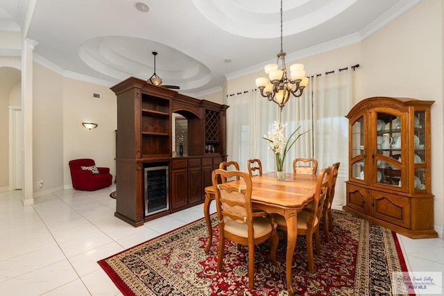 dining room featuring wine cooler, a raised ceiling, crown molding, and baseboards