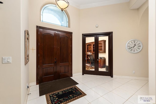 foyer featuring ornamental molding, baseboards, and tile patterned floors