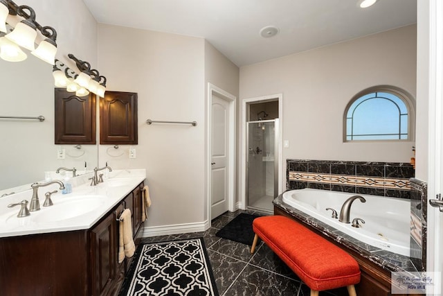 full bath featuring a stall shower, baseboards, a tub with jets, and a sink