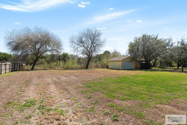 view of yard with an outbuilding, fence, a detached garage, and an outdoor structure