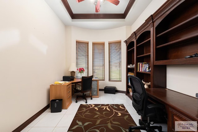 office space with light tile patterned floors, a ceiling fan, baseboards, a raised ceiling, and crown molding