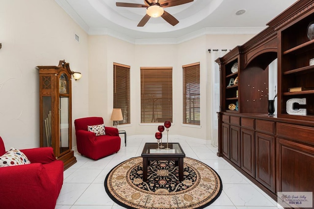 sitting room featuring ceiling fan, light tile patterned flooring, visible vents, a raised ceiling, and crown molding