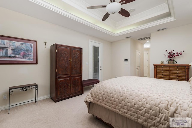 bedroom featuring light carpet, visible vents, a tray ceiling, and ornamental molding