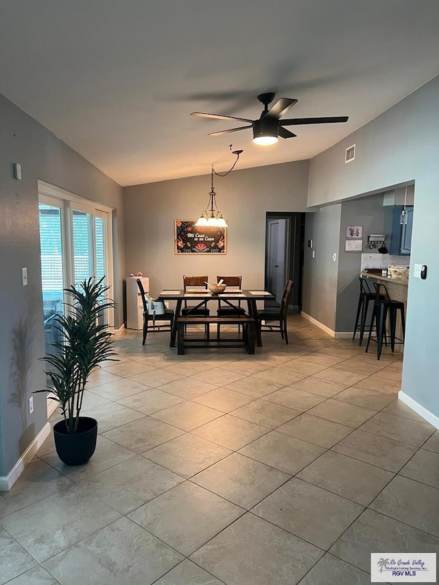 dining area featuring ceiling fan, vaulted ceiling, and light tile patterned floors