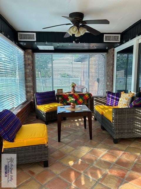 sunroom / solarium featuring ceiling fan