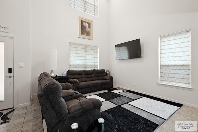 tiled living room with a high ceiling and a wealth of natural light