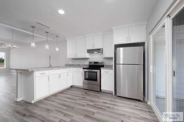 kitchen with kitchen peninsula, light wood-type flooring, appliances with stainless steel finishes, decorative light fixtures, and white cabinetry