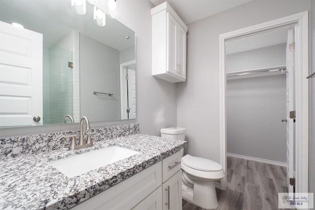 bathroom featuring hardwood / wood-style floors, vanity, toilet, and an enclosed shower